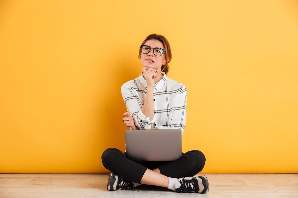 A thoughtful woman using her laptop