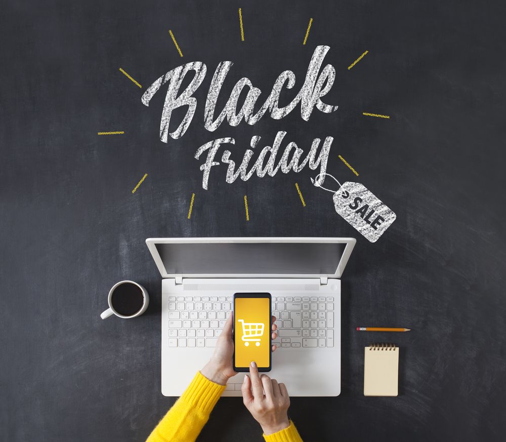 "Black Friday SALE" written on a table of coffee and electronics