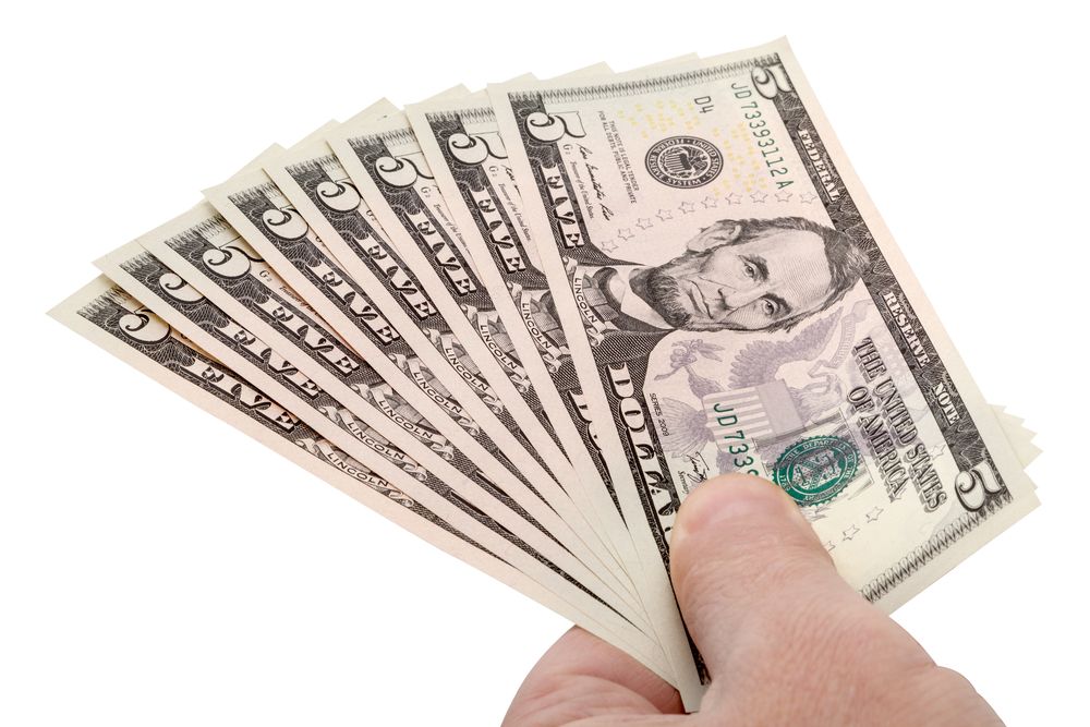 Eight five-dollar bills being held