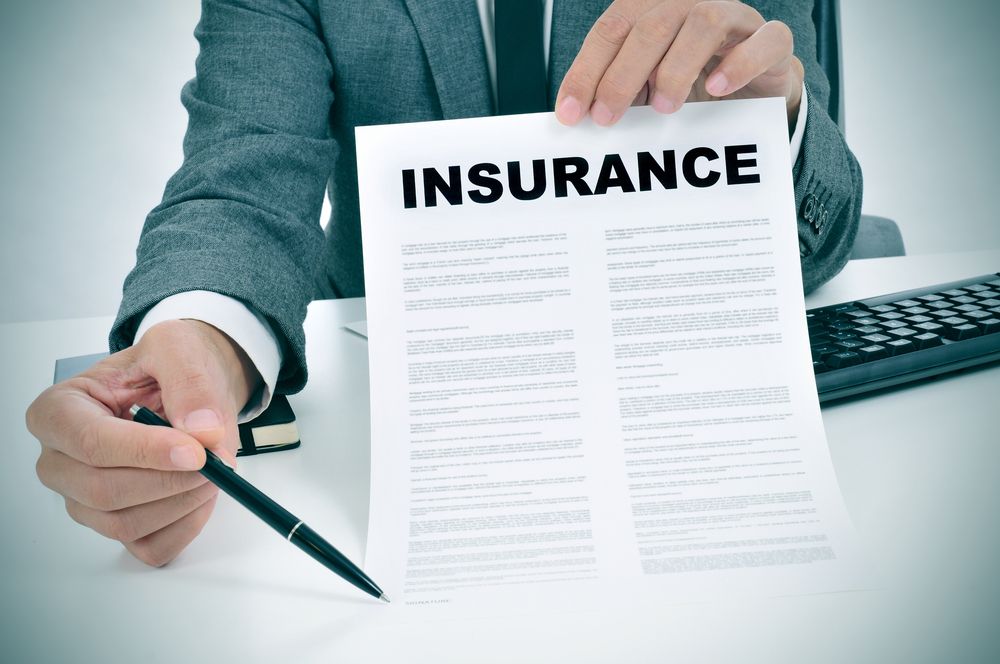 A man offering a pen and an insurance policy