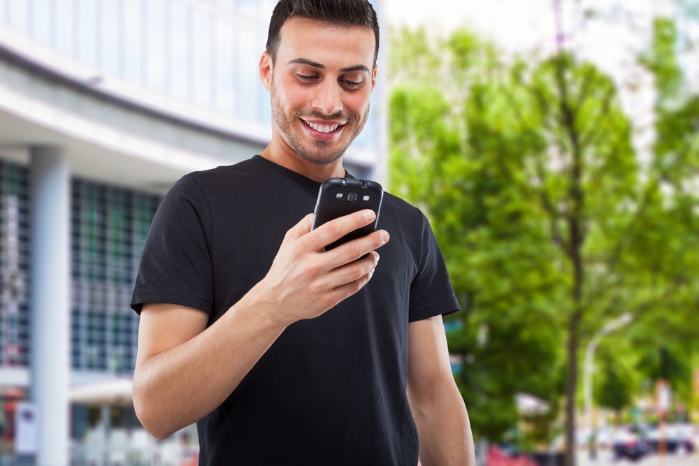 A man smiling on his phone