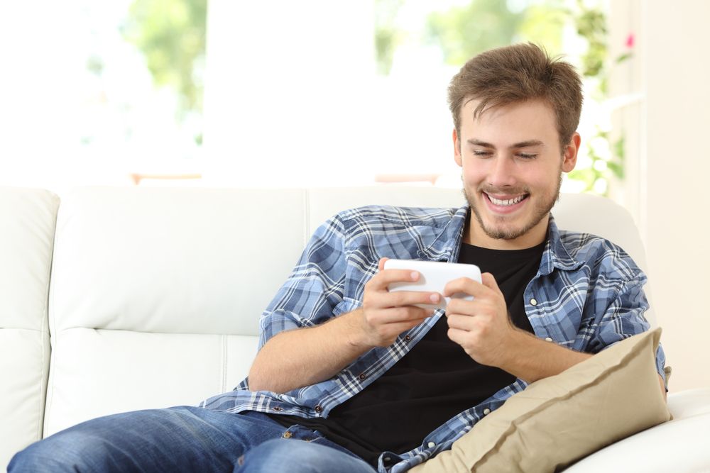 A man using a phone while sitting on a couch