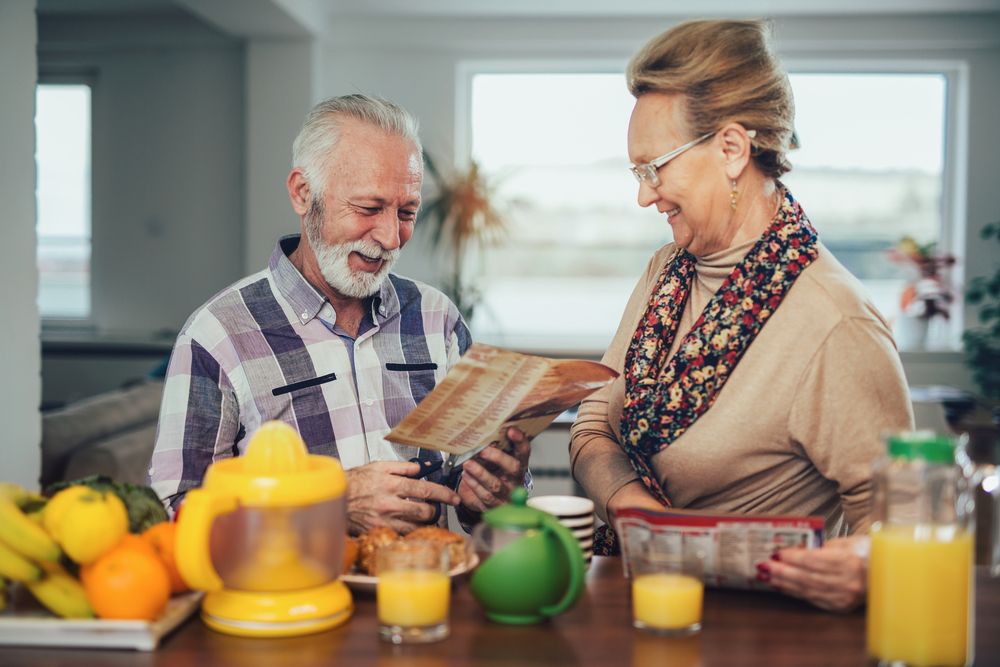 A senior couple looking at a supermarket flyer
