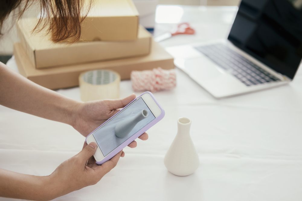 A woman taking a picture of a vase