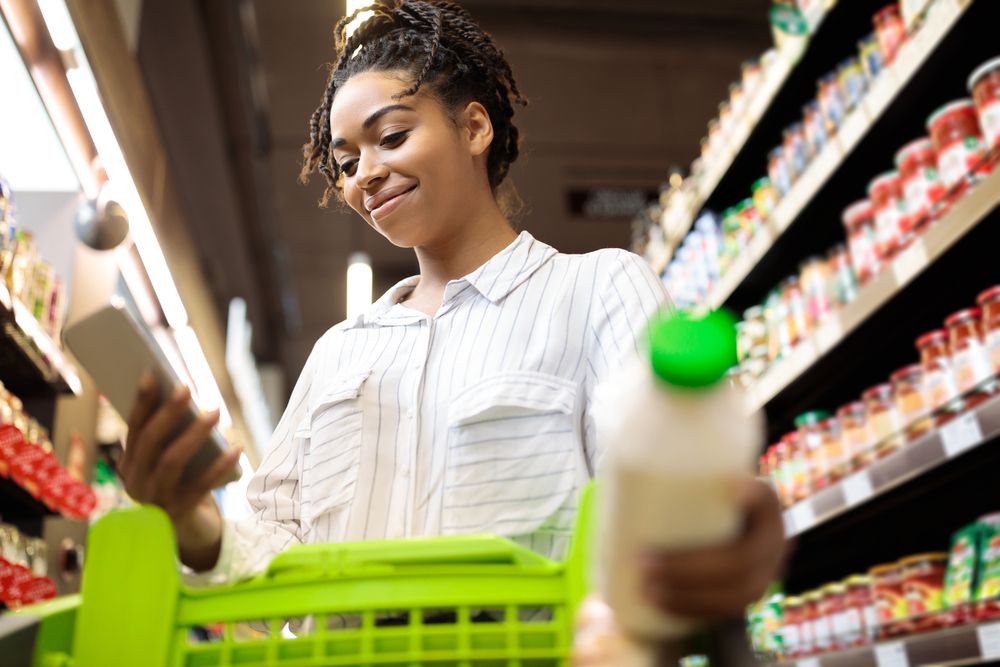 A woman using a mobile phone while grocery shopping