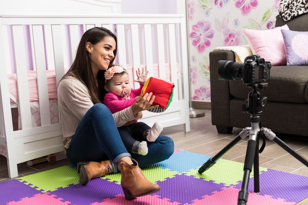 A woman with a baby filming a video