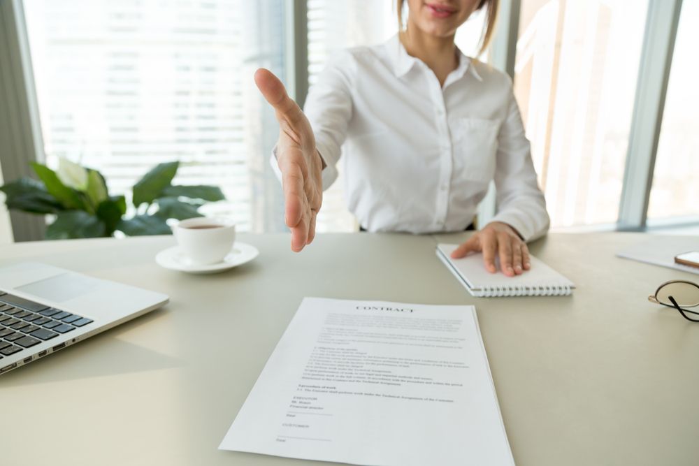 A woman offering a contract and a hand