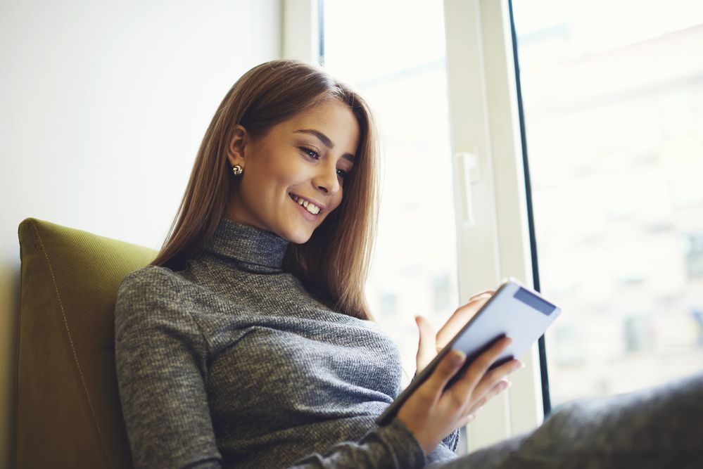 A smiling woman using a tablet