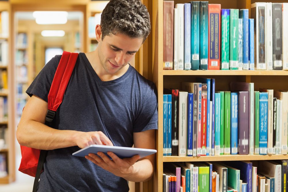 A young man standing inside a library